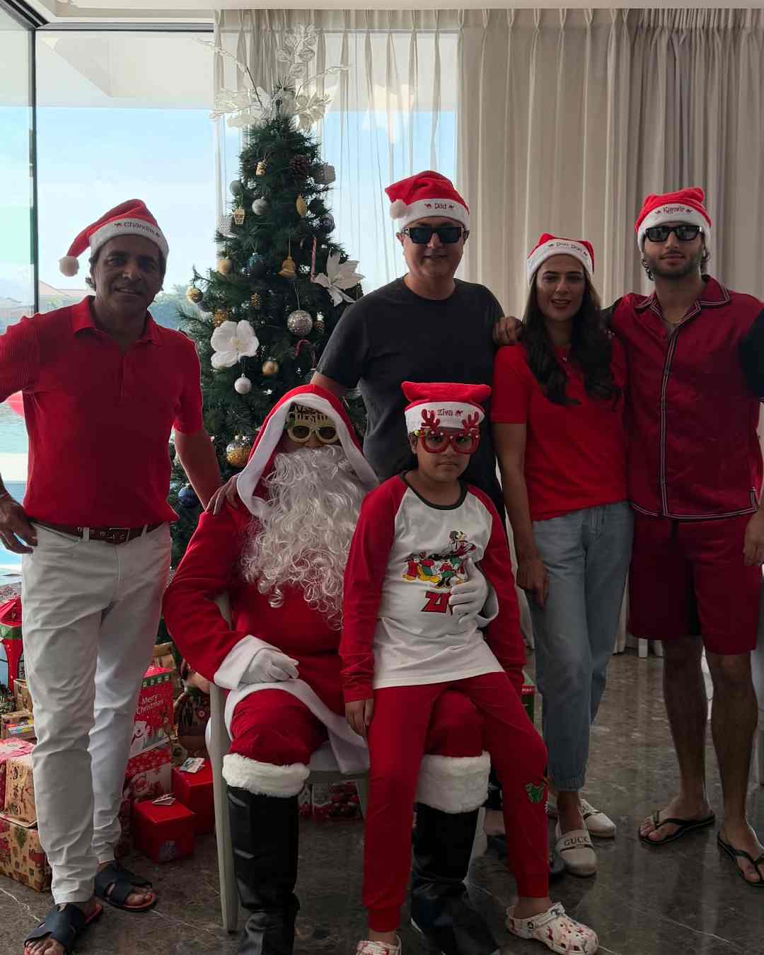 Ziva sat on Dhoni's lap. The photo shows the father-daughter duo surrounded by their close ones.  