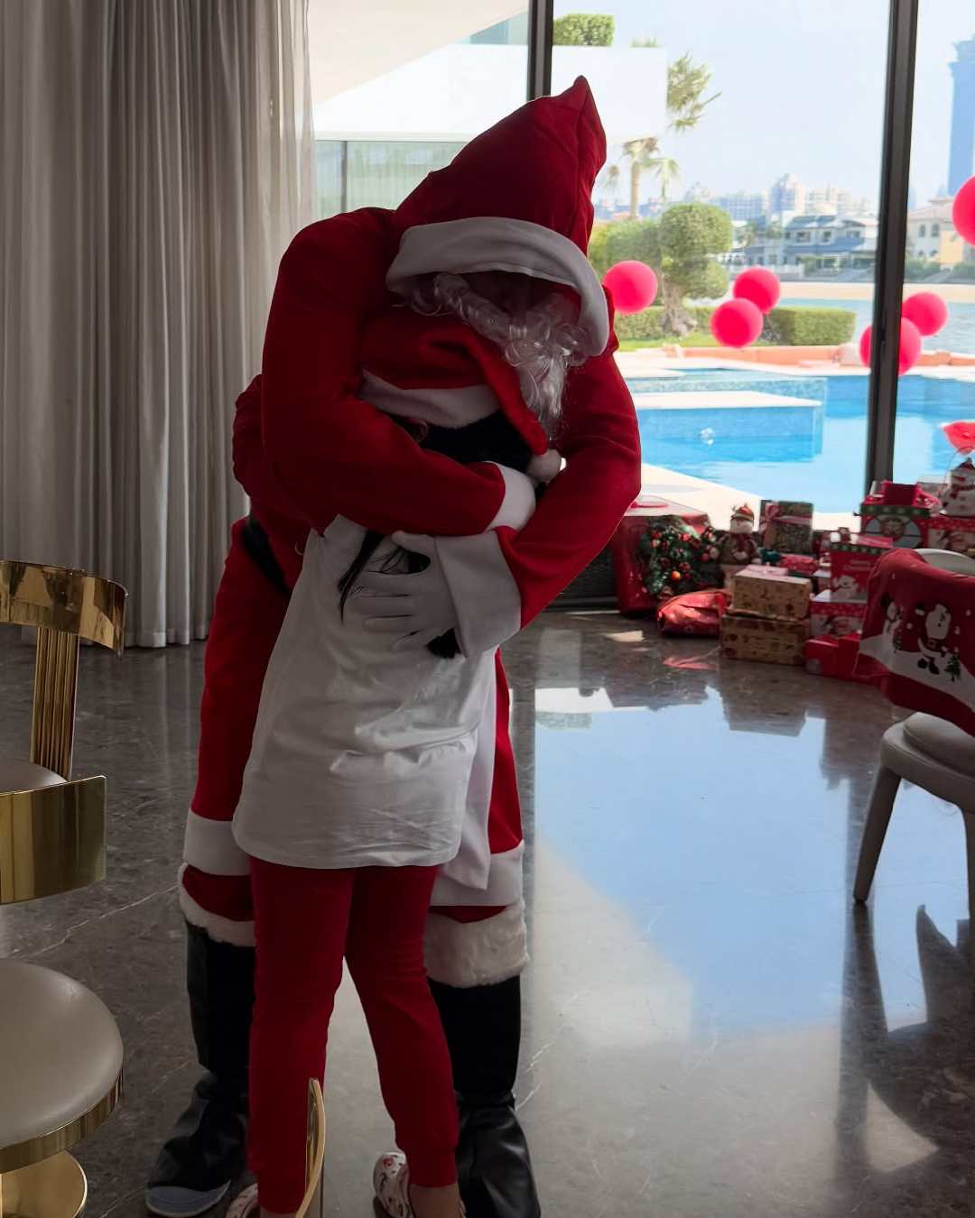 An adorable candid photo shows Ziva embracing Dhoni.  