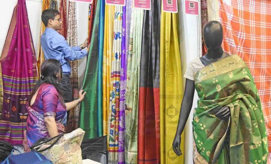 Visitors browse through saris at a stall at Kreta Suraksha Mela 2024-2025 at Netaji Indoor Stadium on Friday. The fair will continue till December 28