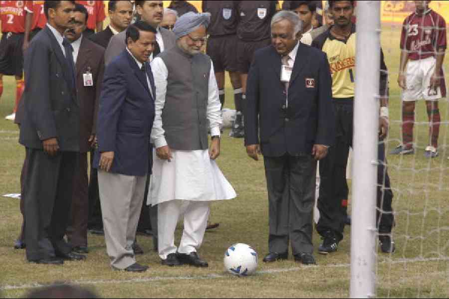 In this picture from January 12, 2005, Manmohan Singh, flanked by the then All India Football Federation president Priya Ranjan Das Munshi (left) and ONGC top boss Subir Raha, kicks off the 2004-2005 National Football League at the Salt Lake Stadium. East Bengal captain (extreme right, yellow shirt) Sangram Mukherjee looks on. A file picture