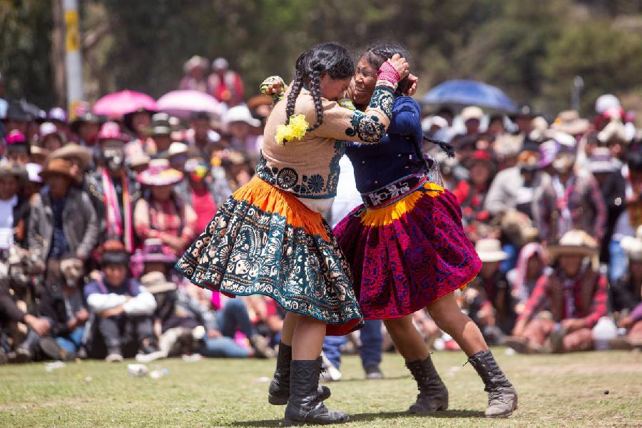 Bond over battle: Women clinch in the middle of their fight. 