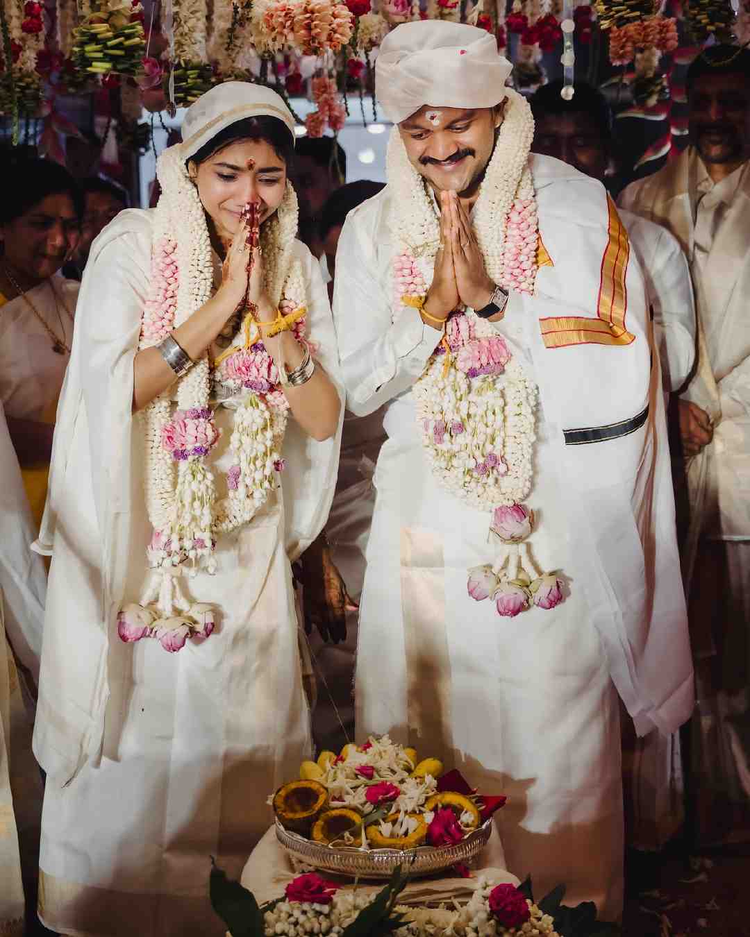 The photo shows the bride and the groom performing rituals during their wedding ceremony. Both Pooja and Vineeth sport white ensembles in the picture. 