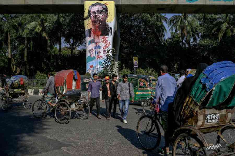 (Above) A defaced portrait of Sheikh Mujibur Rahman in Dhaka in November