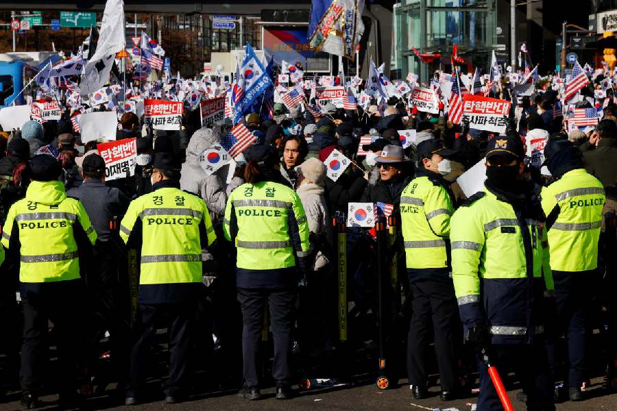 Police officers take position as demonstrators opposing the court's approval of an arrest warrant for impeached South Korean President Yoon Suk Yeol protest outside his official residence in Seoul, South Korea, December 31, 2024. Reuters