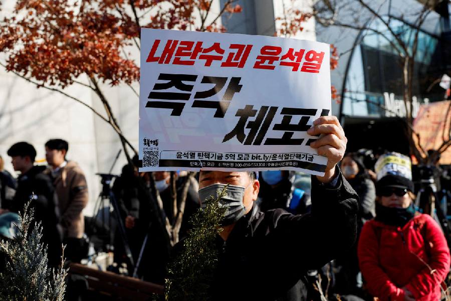A protester who agrees to the court's approval of an arrest warrant for impeached South Korean President Yoon Suk Yeol, holds a banner that reads, "Arrest rebellion leader Yoon Suk Yeol right now," outside Yoon's official residence in Seoul, South Korea, December 31, 2024. Reuters