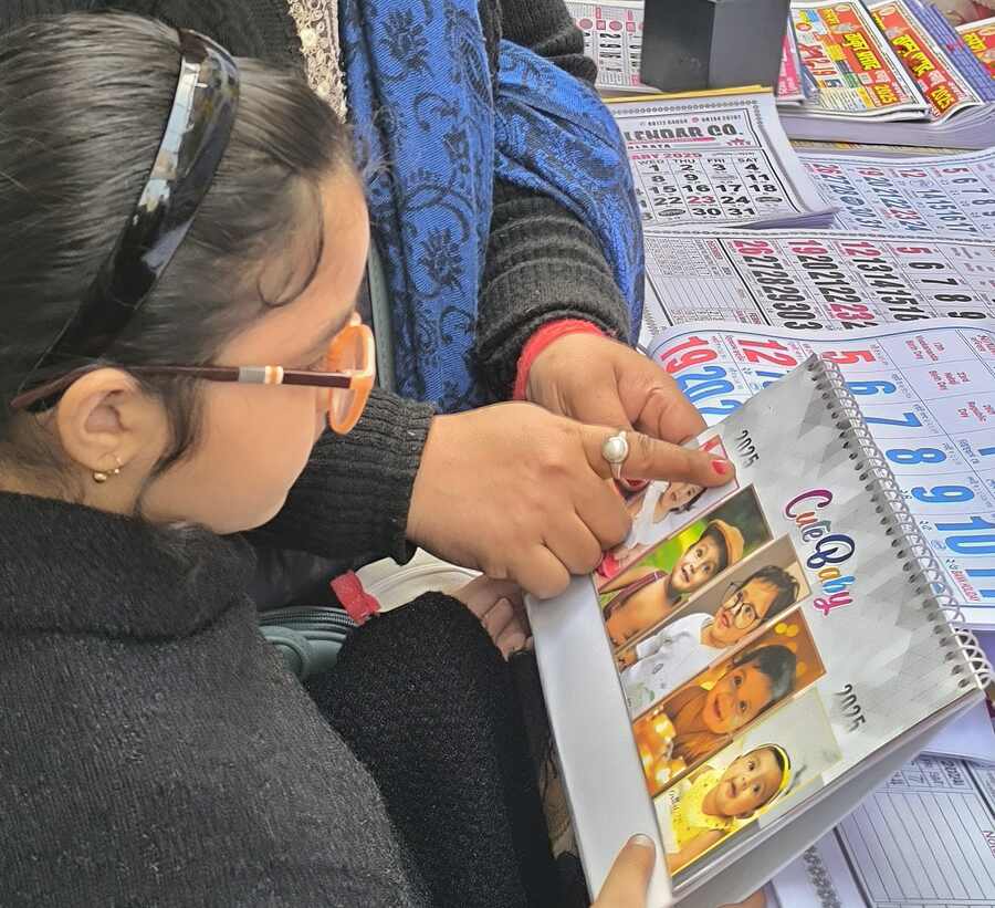A mother-daughter duo buy a desk calendar for 2025 at Esplanade on New Year’s Eve