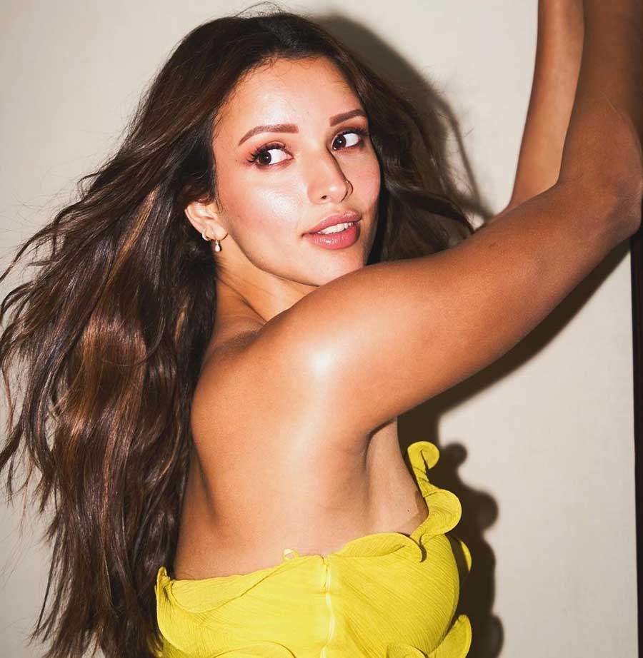 Triptii wore a coral pink lipstick, pearl earrings and a nose pin with her yellow dress.