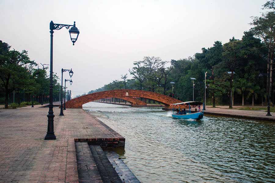 A boat passes beneath the arched bridges spanning across the water canals 