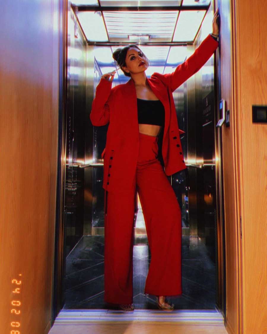 Sonakshi Sinha kills it in a black tube top worn underneath a red blazer, paired with red trousers. Heeled sandals and a messy bun accentuated her ensemble. 