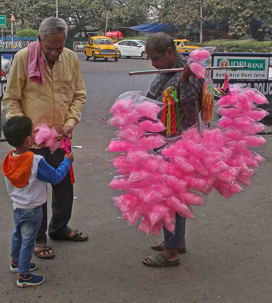 Enjoying a midweek holiday, a child takes a stroll with his grandfather at Victoria Memorial and gets a ‘Hawai Mithai’ candy  
