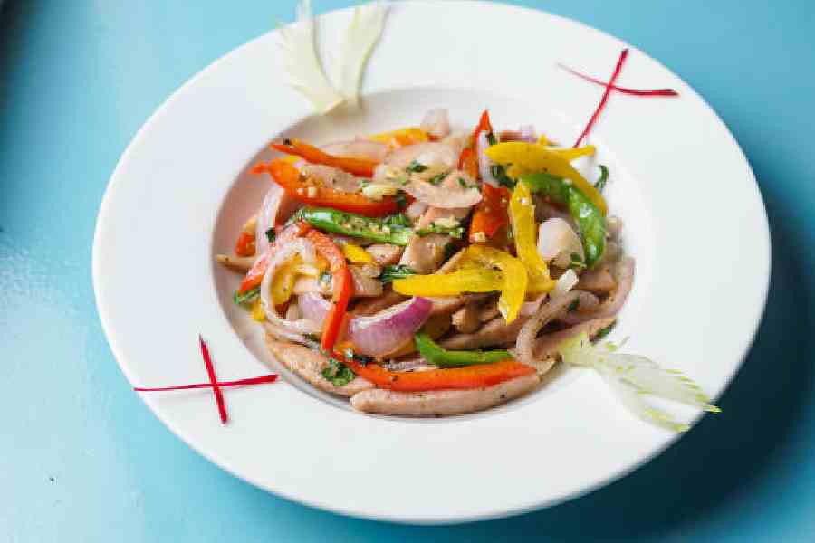 Explore a riot of colours and flavours with the Chili Bell Pepper Pork. Sliced pork sausages paired with vibrant red, yellow, and green bell peppers, and tossed with onions, green chilli, basil, butter, garlic, salt, and black pepper, are a treat for your palate