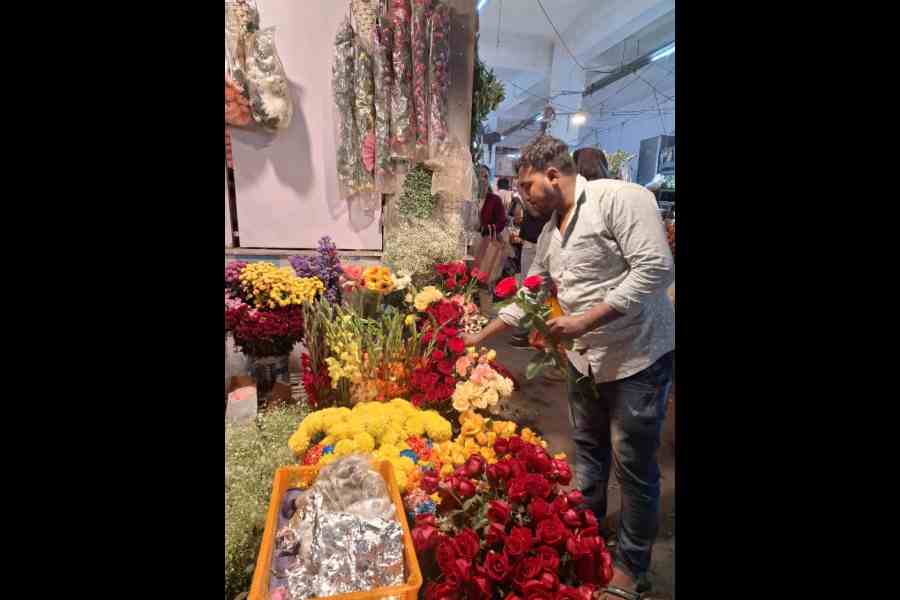 A vendor decorates flowers at his stall in BD Market