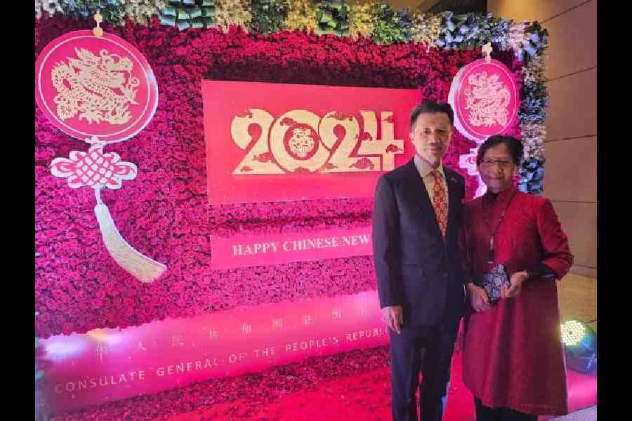 Chinese consul general Zha Liyou and his wife Zheng Huiqun pose in front of a New Year backdrop 