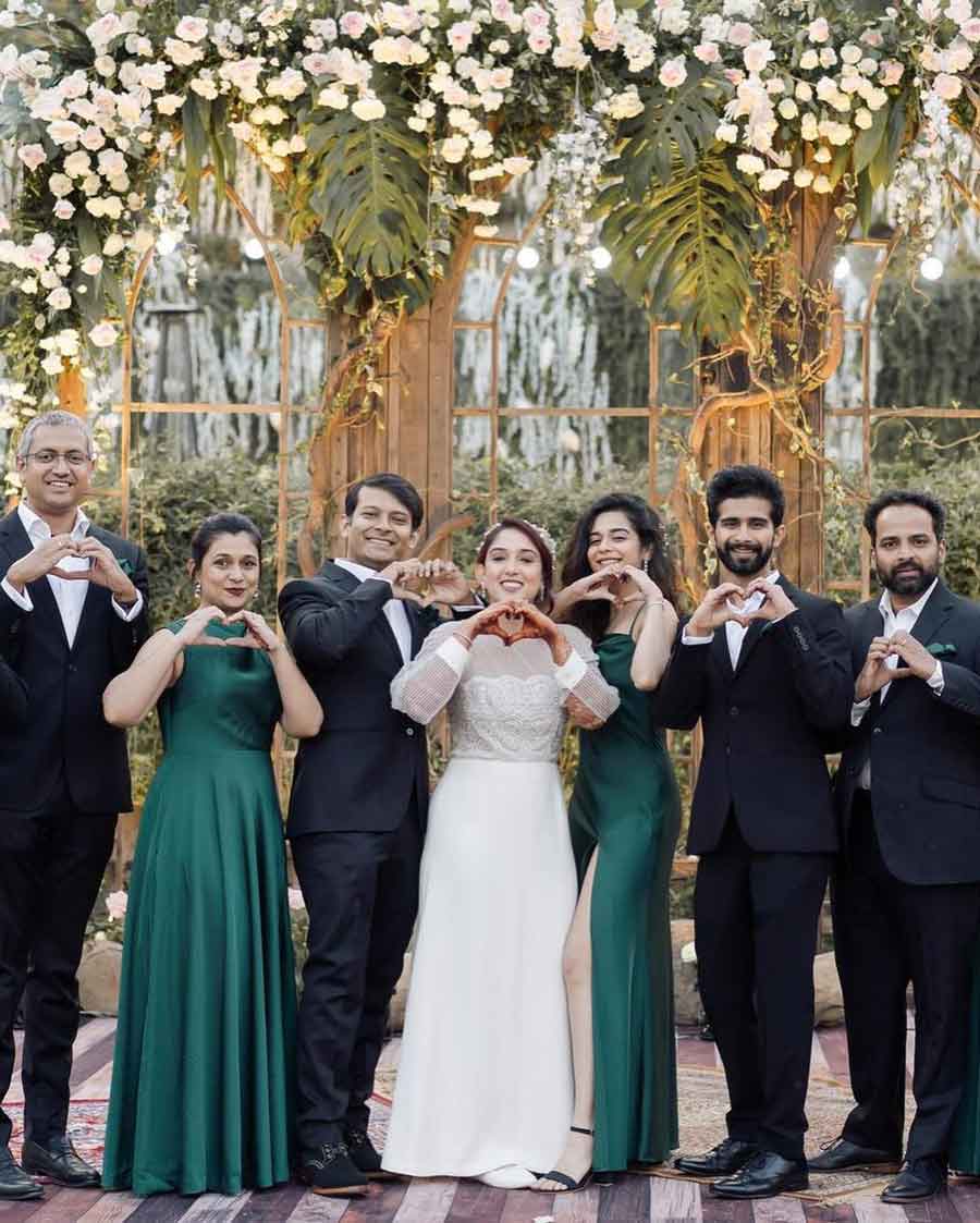 The groom team and the bridesmaids team joined their hands into heart signs while posing for the lens. Ira stood in the middle, looking ethereal in a white wedding gown coupled with simple drop earrings and a floral tiara.