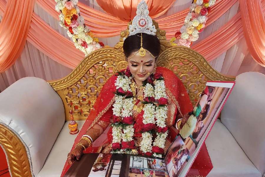 A Karunamoyee bride browses her pre-wedding photo album