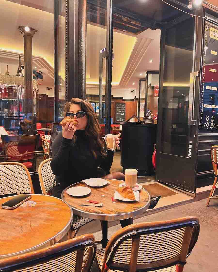 Rocking a black outfit amidst the spring hues in Paris, Gomez tucked into cream-filled croissants and enjoyed a hot brew at a cafe.
