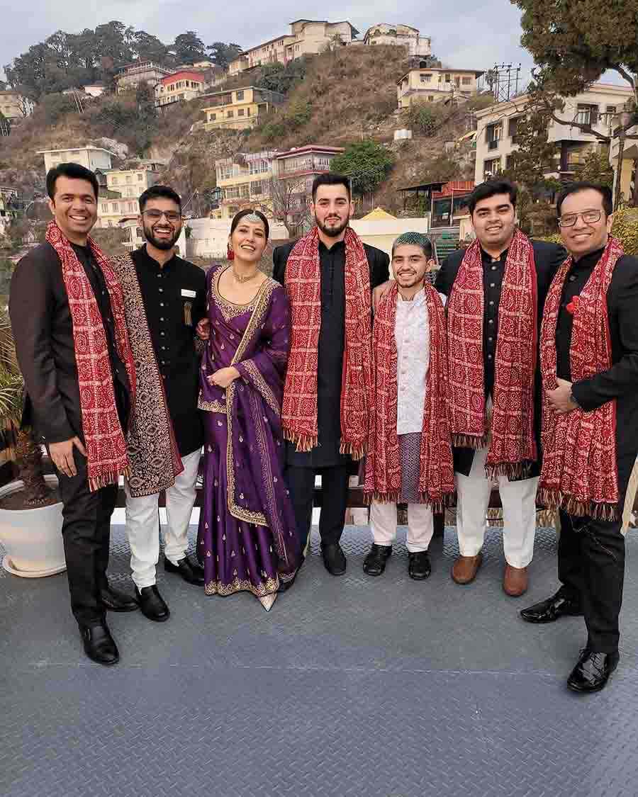 Raashii struck a pose with the groomsmen at the wedding in the backdrop of a hill dotted with little cottages.