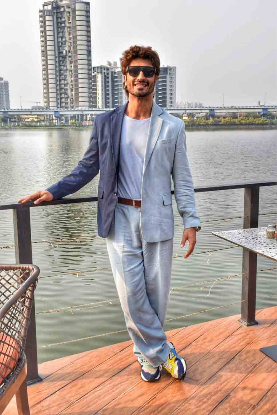 The actor wore a dark blue blazer over a t-shirt and matching trousers. Black shades and blue-and-yellow shoes complemented his look for the day.  