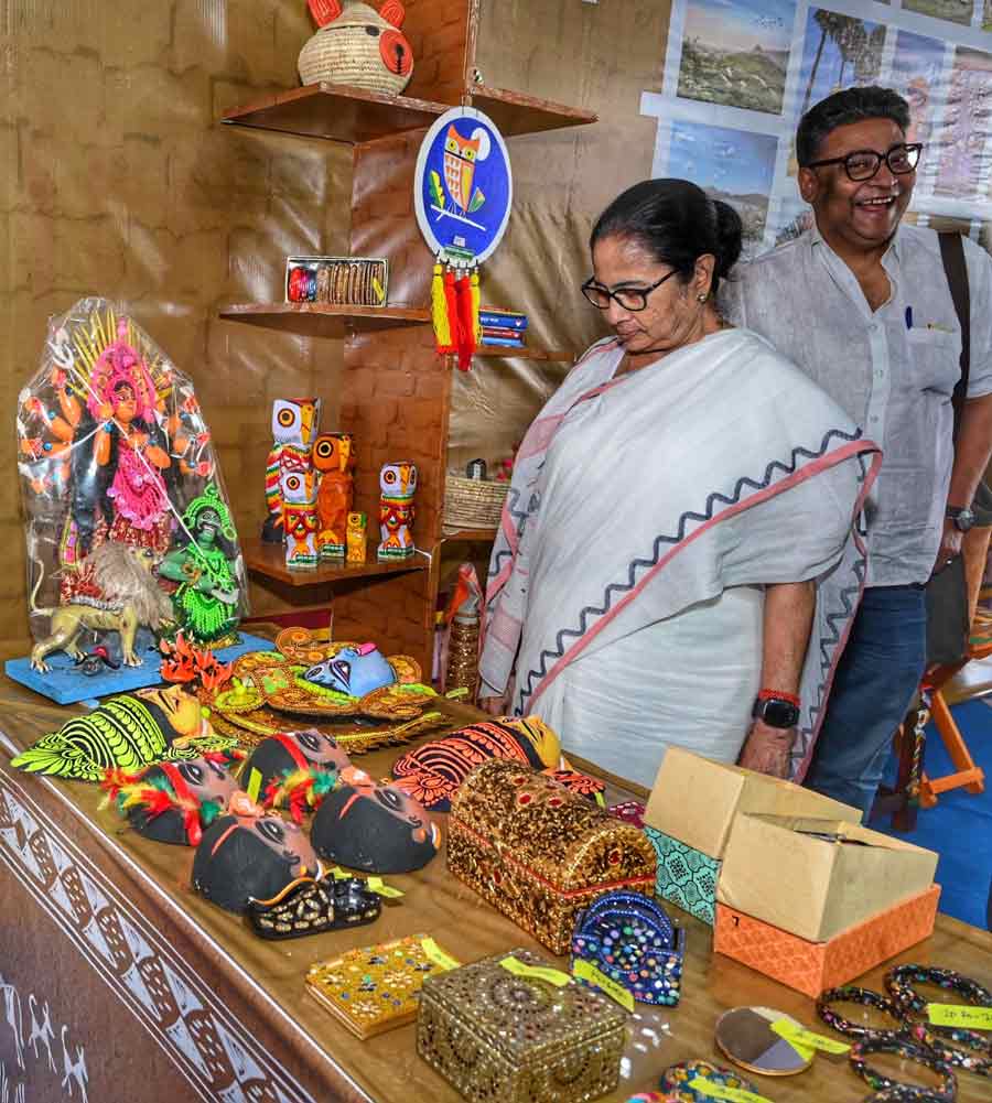 Chief minister Mamata Banerjee takes a look at Chhou masks at a fair in Purulia on Tuesday. With her was minister and singer Indranil Sen