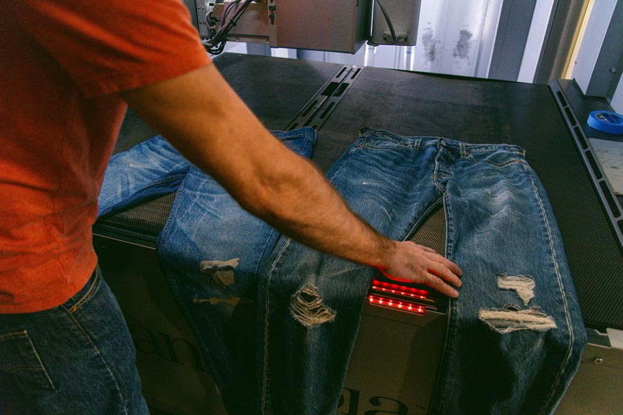 A Levi’s employee compares a pair of jeans that have been washed, right, with a fresh pair of jeans at the company’s Eureka Lab in San Francisco, Feb. 1, 2024.