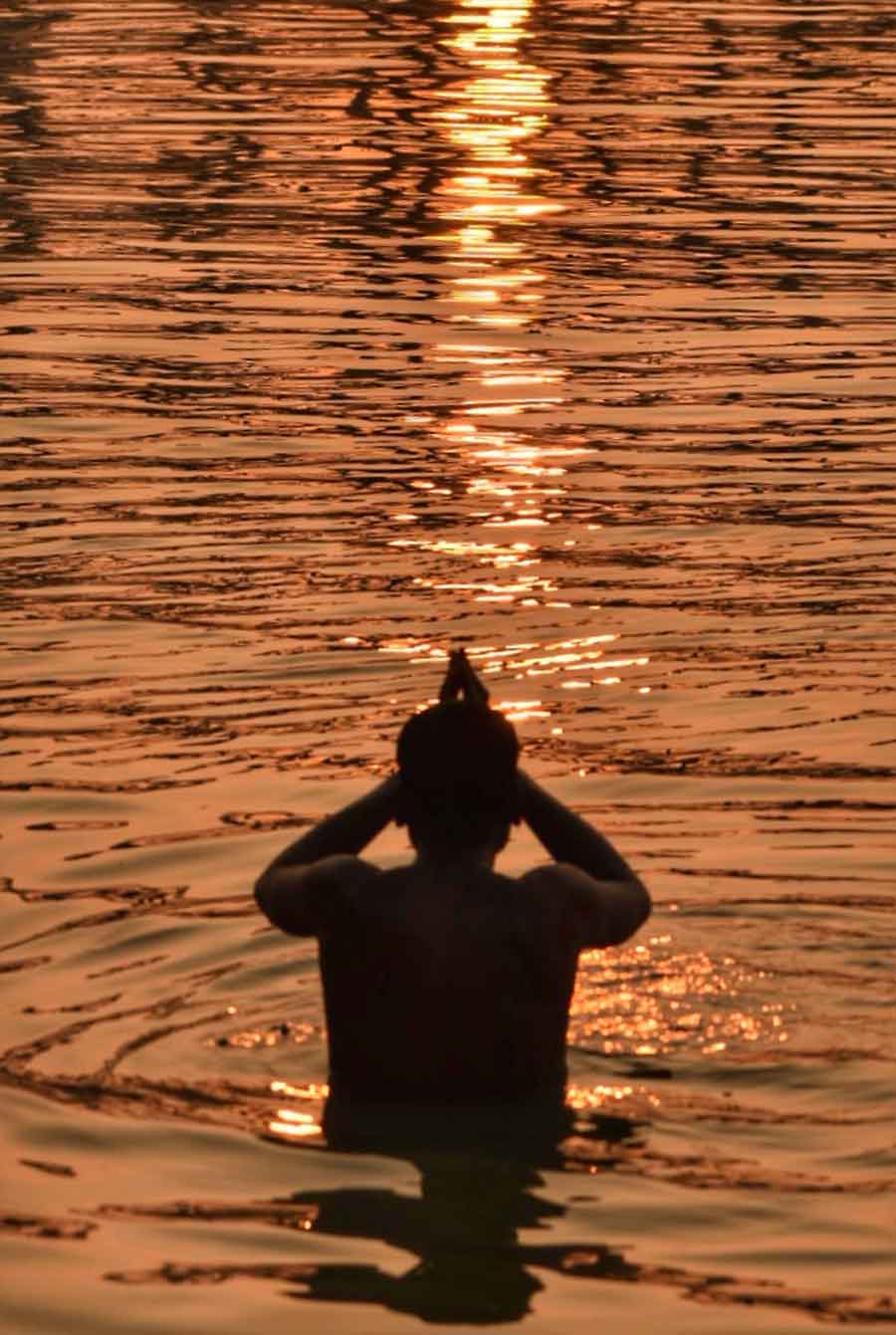 A man takes his last dip of the year 2023 in the Hooghly just before sunset on Sunday 