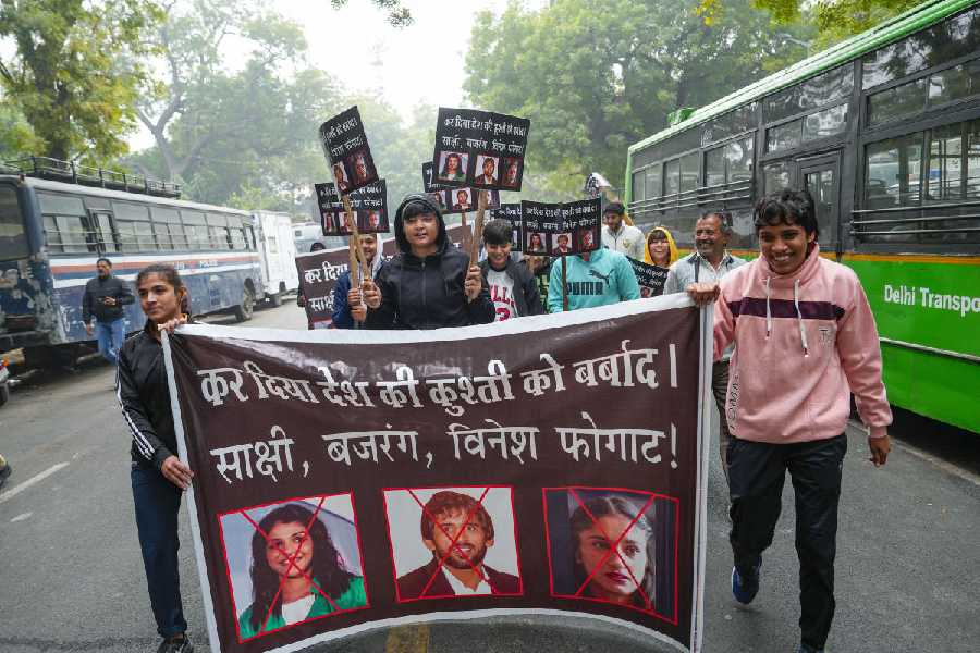 Young wrestlers hold placards during a protest against wrestlers Sakshi Malik, Bajrang Punia and Vinesh Phogat at Jantar Mantar, in New Delhi, Wednesday
