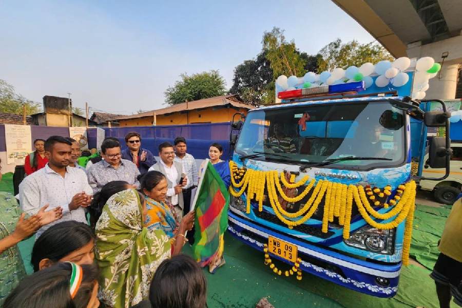 Women of Duttabad wave a flag before the mobile toilet, as councillor Rajesh Chirimar, Arijit Banerjee and others look on.