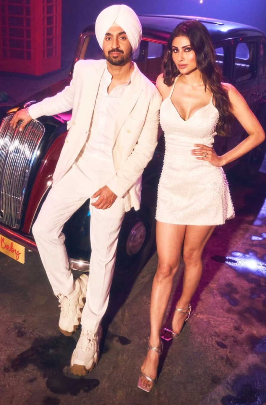 While Diljit slayed in a white suit paired with white sneakers and a white turban, Mouni looked gorgeous in a white strappy dress and silver stilettos in one of the sequences of the music video. 