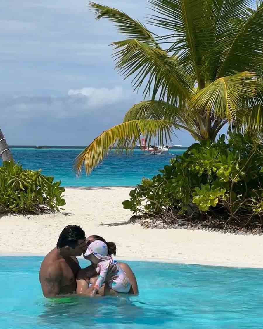 The actress enjoyed her time in the pool as she shared a kiss with husband Karan and cradled little Devi in her arms. 