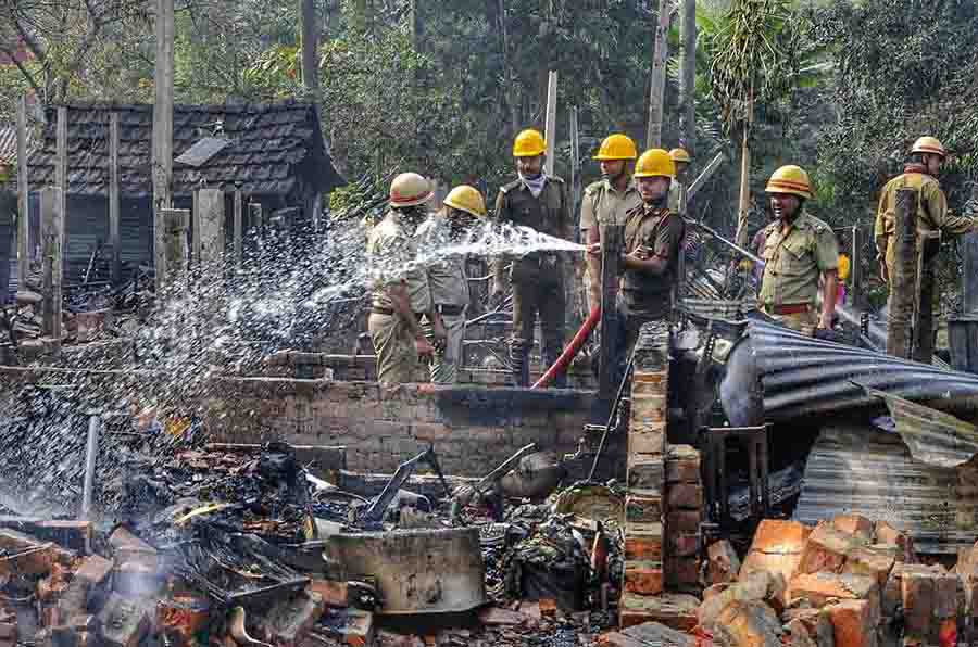 Fire personnel douse a blaze at a slum near Dhalai bridge in Garia on Monday. Smoke started billowing around 11am following which local residents panicked out of their homes