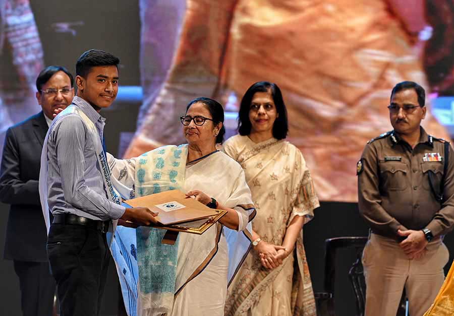 Chief minister Mamata Banerjee hands over prizes to students at the concluding programme of Students’ Week at the Dhono Dhanya auditorium in Alipore on Monday