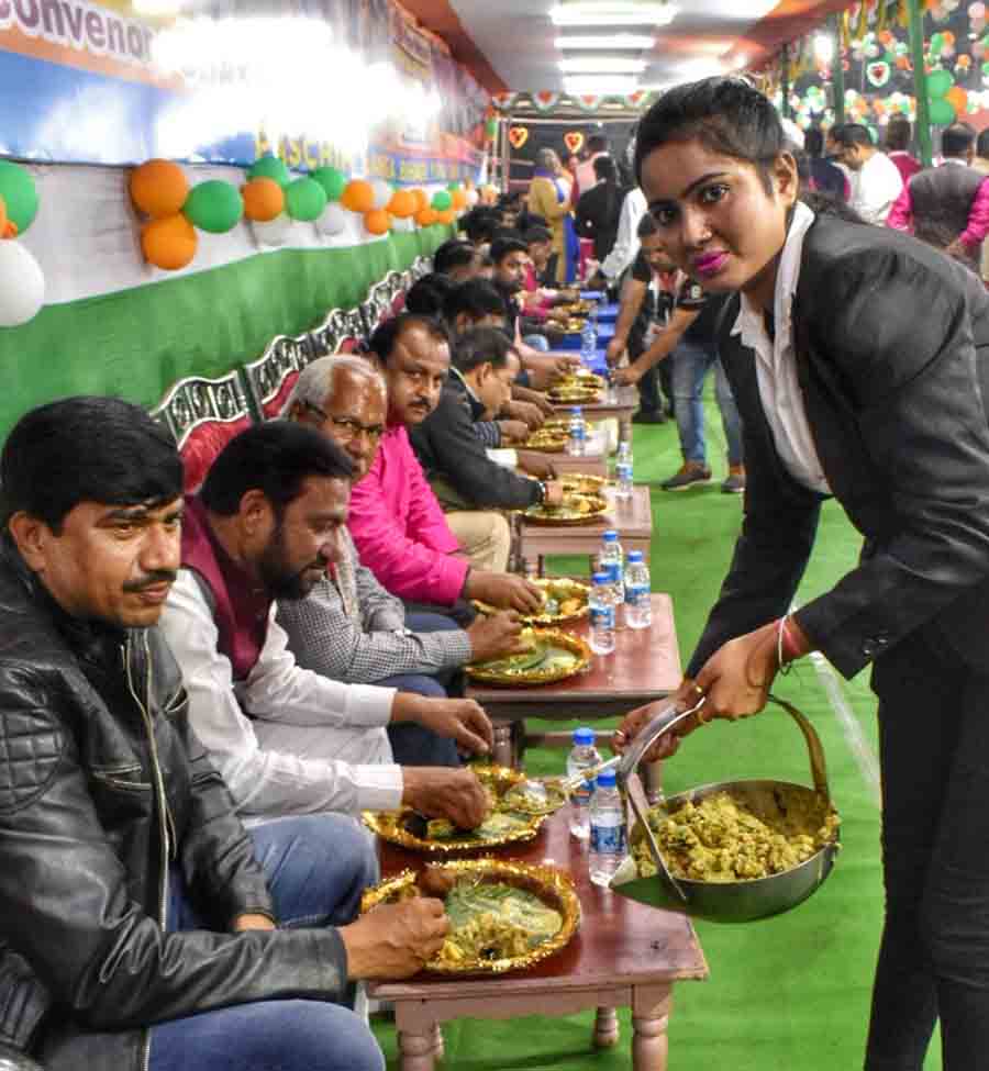 A young lady serves the chokha to be consumed with littis by diners at the event 