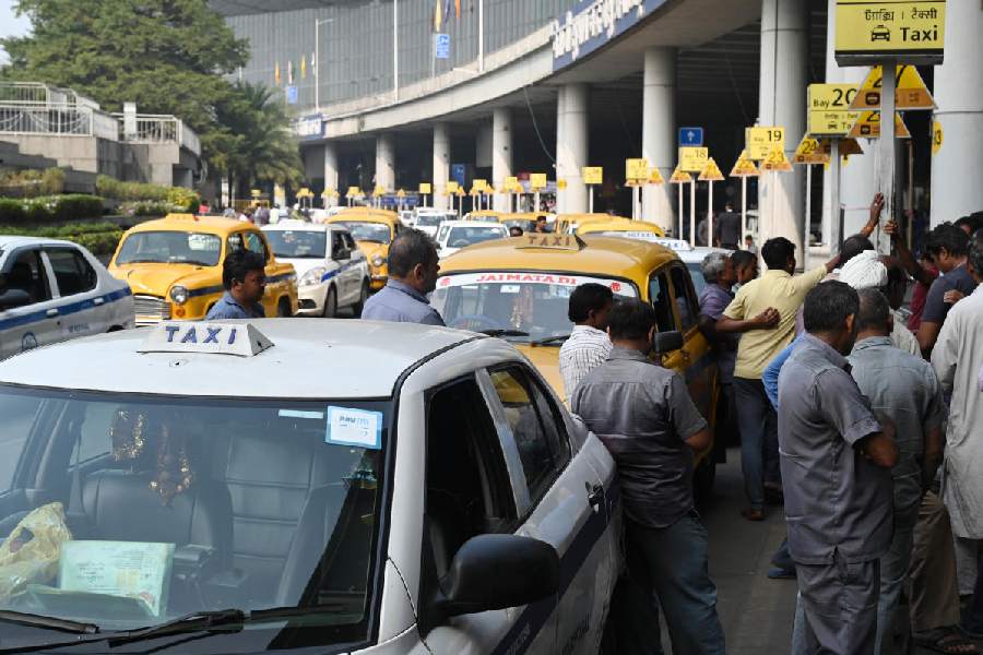 Cab drivers crowd around the taxi booth outside the terminal building of the airport on Wednesday.