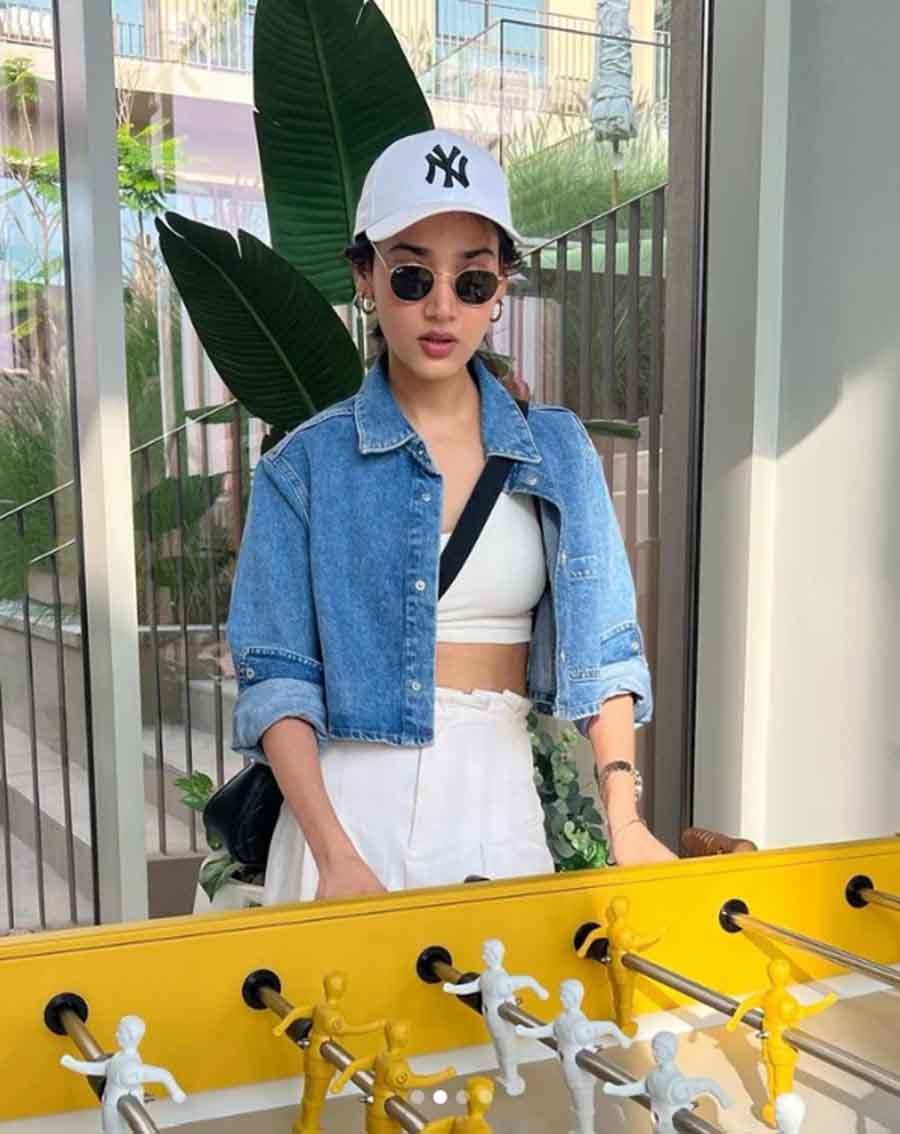 For a game of foosball, Medha nailed the casual chic look in a white coordinated top and pants, and a short denim jacket. The cap, shades, hoops and crossbody bag complete the holiday vibe.