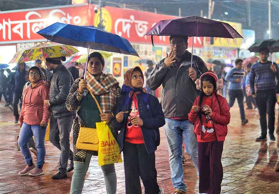 Booklovers explore the International Kolkata Book Fair with umbrellas amidst rain on Wednesday evening  