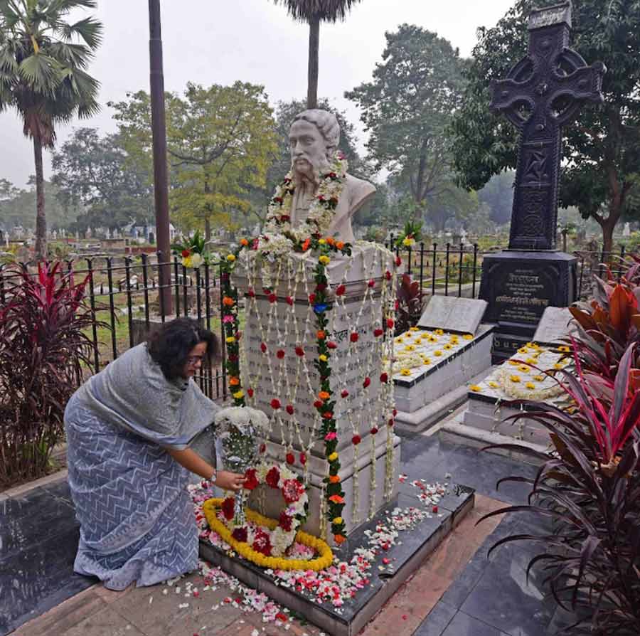A woman offers floral tribute at the grave of Michael Madhusudan Dutt on his birth anniversary at Lower Circular Road Cemetery  