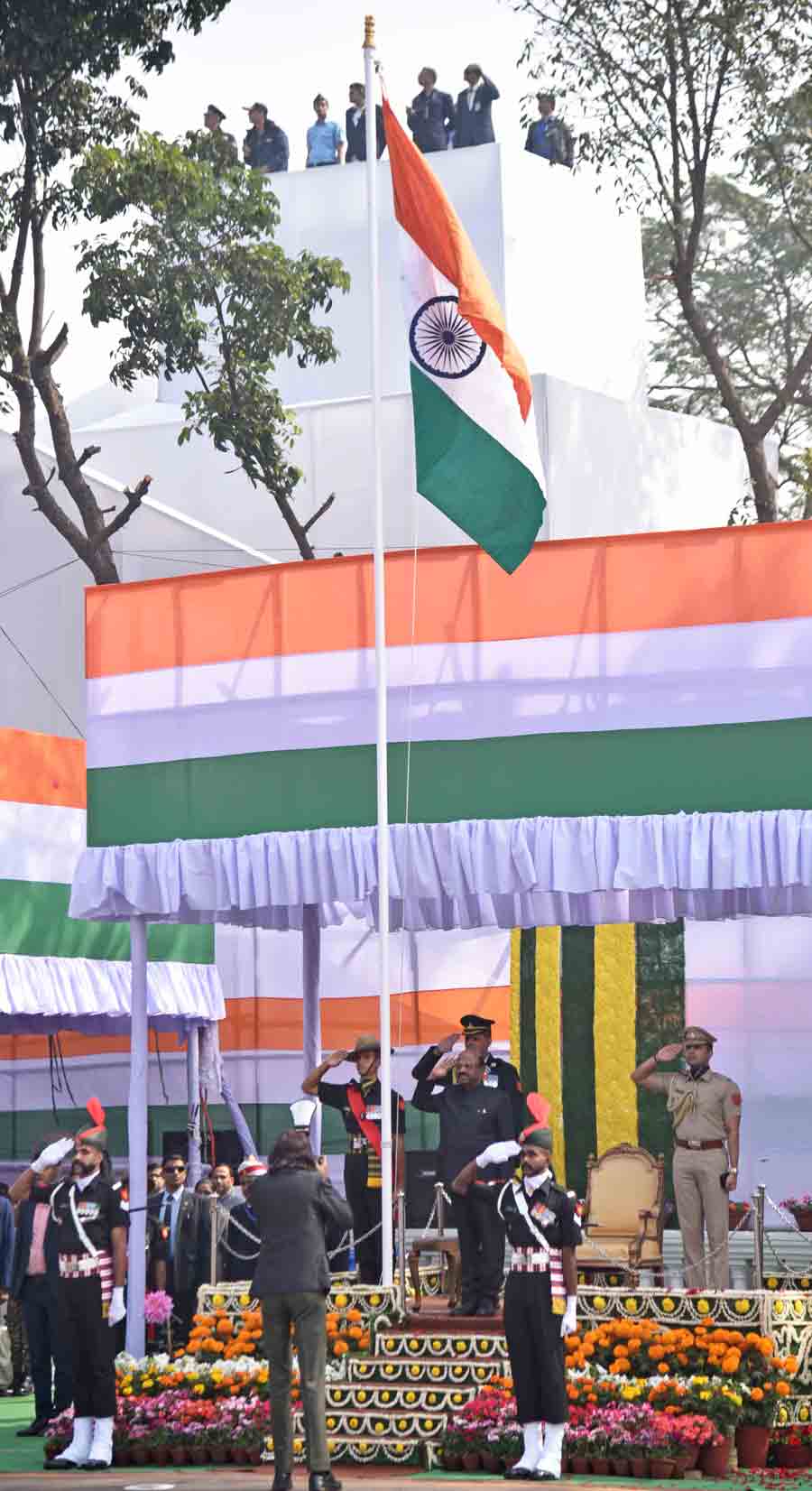 Governor CV Ananda Bose salutes while the National Anthem is played following the hoisting of the Tricolour 