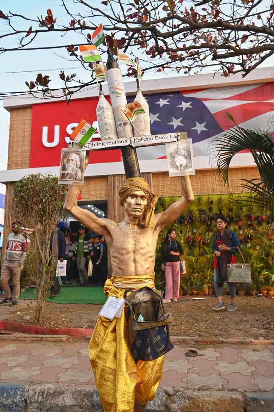Many people find a way of earning at the Book Fair by showcasing their talents. In picture, a man poses as a statue lifting up a replica of the Chandrayaan