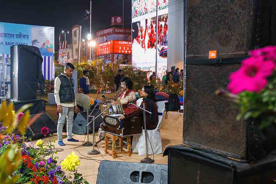 A group of youngsters spend time at the Boi Mela singing and strumming guitar