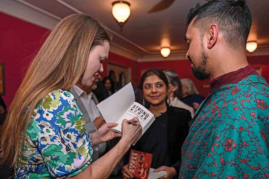 Ida Jo Pajunen signs a copy of her book, flanked by educationist Bratati Bhattacharyya, and Bishan Samaddar, editor at Seagull Books