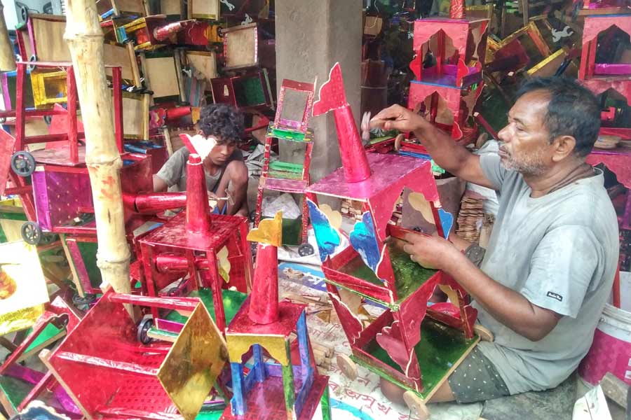 A craftsman in Champahati, Baruipur, works on small chariots ahead of Rath Yatra. These little chariots come in various sizes and colours and range from one-storey to up to five storeys  