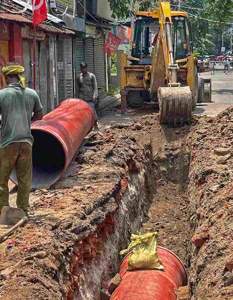 Kolkata Municipal Corporation workers install sewage pipes at Banerjee Para Road near Tollygunge