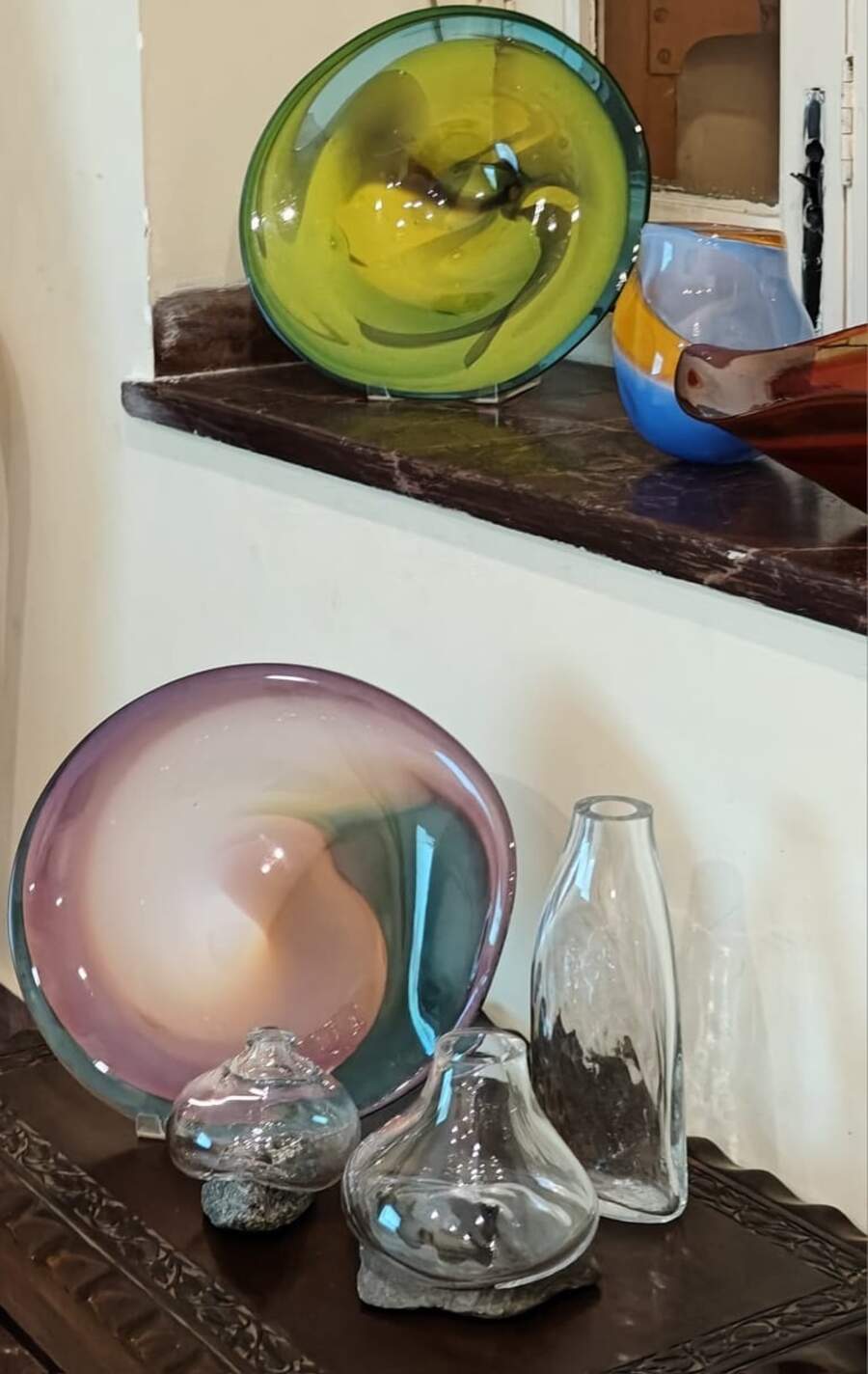 During the lecture, Srila introduced the audience to the fascinating art of glassblowing. This intricate process begins by inflating molten glass into a bubble using a blowpipe, followed by meticulous shaping into various forms, while the glass remains hot and pliable. A few samples of Srila’s blown glass pieces were displayed for attendees to admire