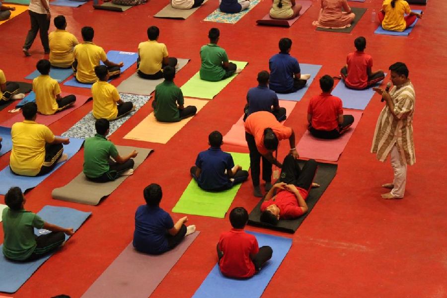 A trainer corrects the posture of a student of DPS (Joka) South Kolkata, at a yoga display