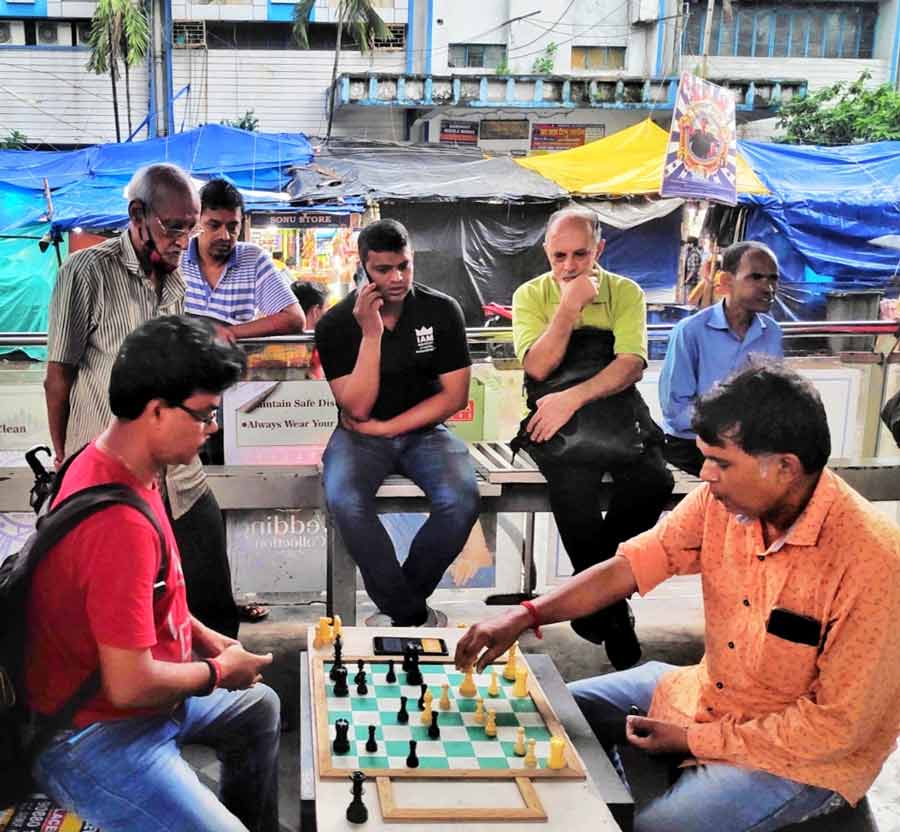 Bystanders watch players at  Gariahat Chess Club  engrossed in a game on Thursday evening