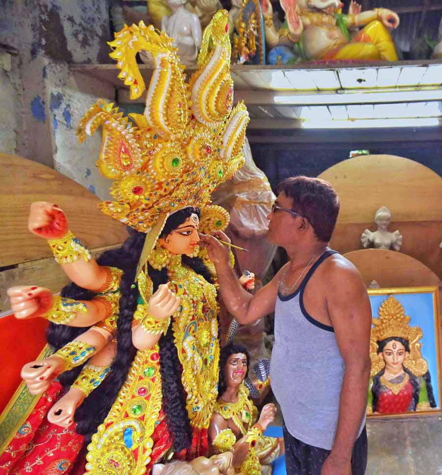 An artist lends finishing touches to a fibre idol being sent to the US