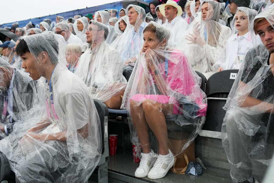 Spectators in ponchos at the Trocadero as rain falls during the opening ceremony of the 2024 Paris Summer Olympics along the Seine in Paris, on Friday, July 26, 2024. 