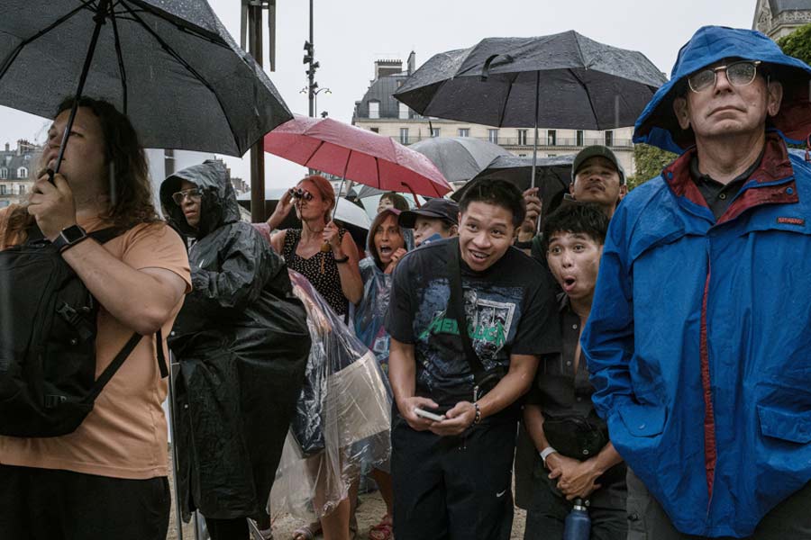 Spectators who lacked tickets tried to get a glimpse of the Parade of Nations from the Parisian streets during the opening ceremony of the 2024 Paris Summer Olympics along the Seine in Paris, on Friday, July 26, 2024. 