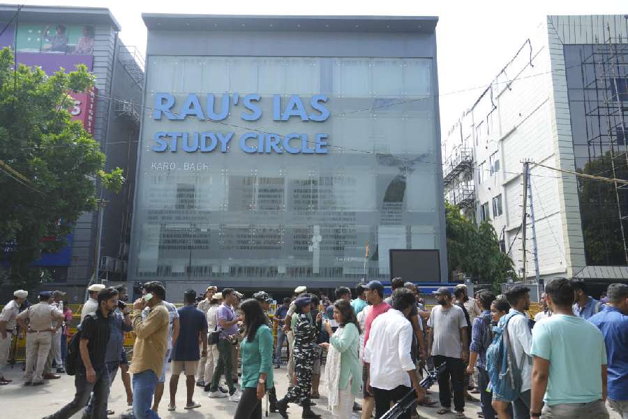 Security personnel stand guard near a UPSC exam coaching centre after three civil services aspirants died when the basement of the coaching centre was flooded by rainwater