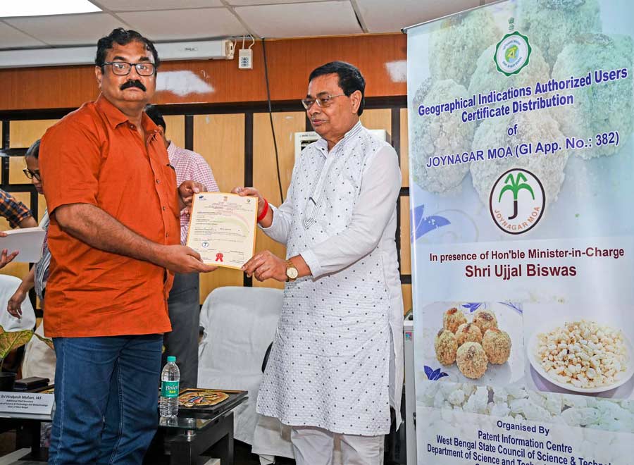 Ujjal Biswas, minister-in-charge of the department of science & technology and biotechnology, handed over Gl-authorised users’ certiflcates to 56 registered Joynagar-er Moa shop owners, including Bablu Ghosh (orange shirt) of Shyamsundar Mistanna Bhandar, at Vigyan Chetana Bhavan, Salt Lake, on Tuesday. The popular Bengali sweet is a winter speciality  